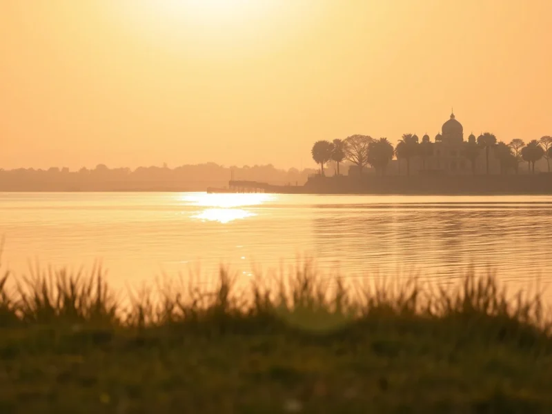 Still lake in Rajasthan at golden hour with a heritage palace soft on the far shoreline in golden haze