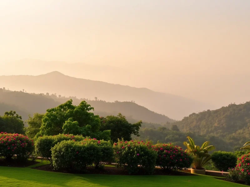 Manicured lawn terrace and flowering shrubs looking across a misty valley to forested Western Ghats ridgelines near Lonavala