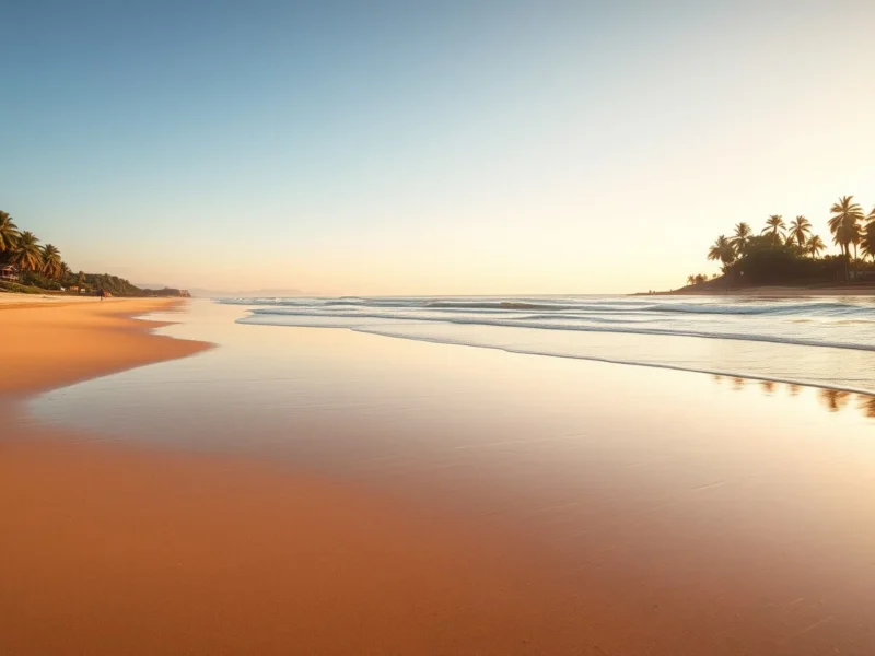 Empty Coromandel coast beach near Pondicherry at golden hour with gentle surf on wet sand and coconut palms along the dune behind